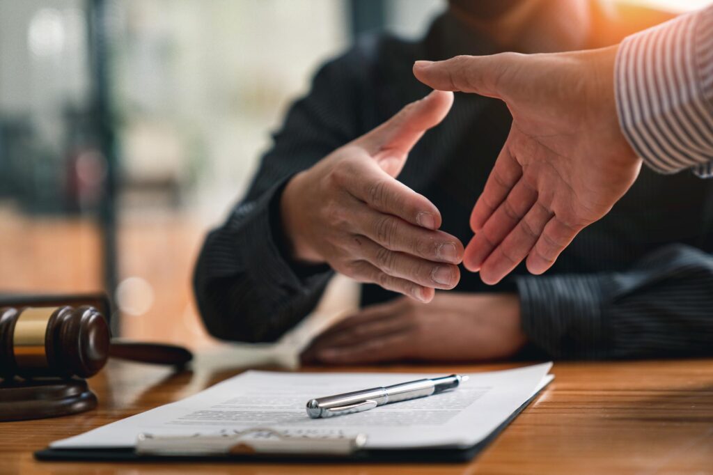 Lawyers shake hands with business people to seal a deal with partner lawyers. or a lawyer discussing contract agreements, handshake concepts, agreements, agreements