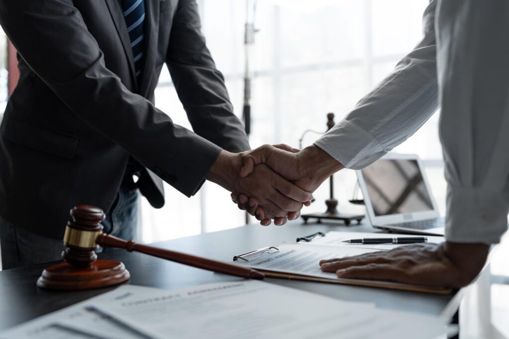 The handshake after a good cooperation, consulting between attorney and client, businessman, tax and real estate project company. Law and justice concept