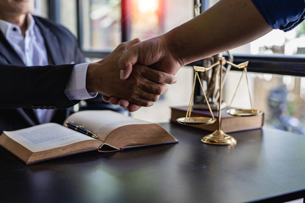 Lawyers shake hands with businessmen to make a deal.