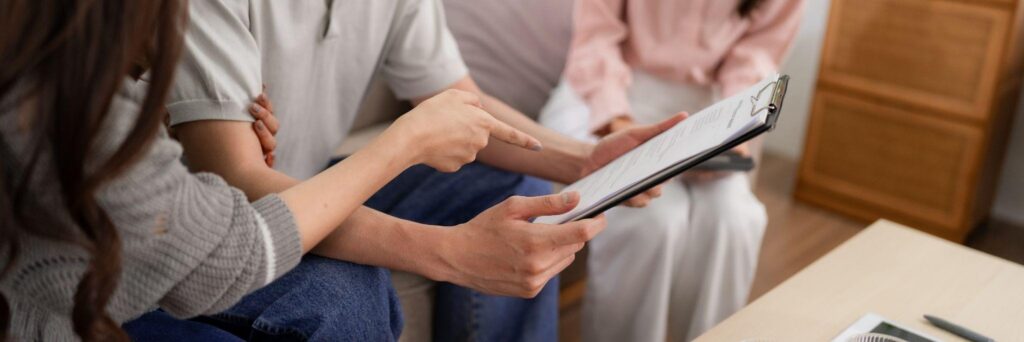 Family members sit together reviewing information on a tablet