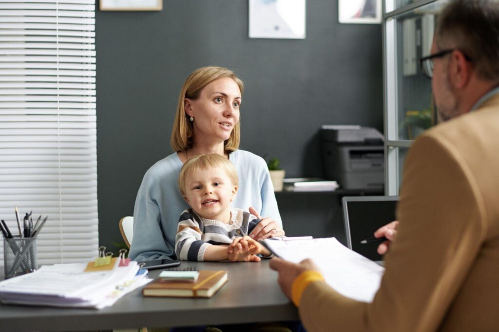 Mother and young son meet with a financial adviser at a desk